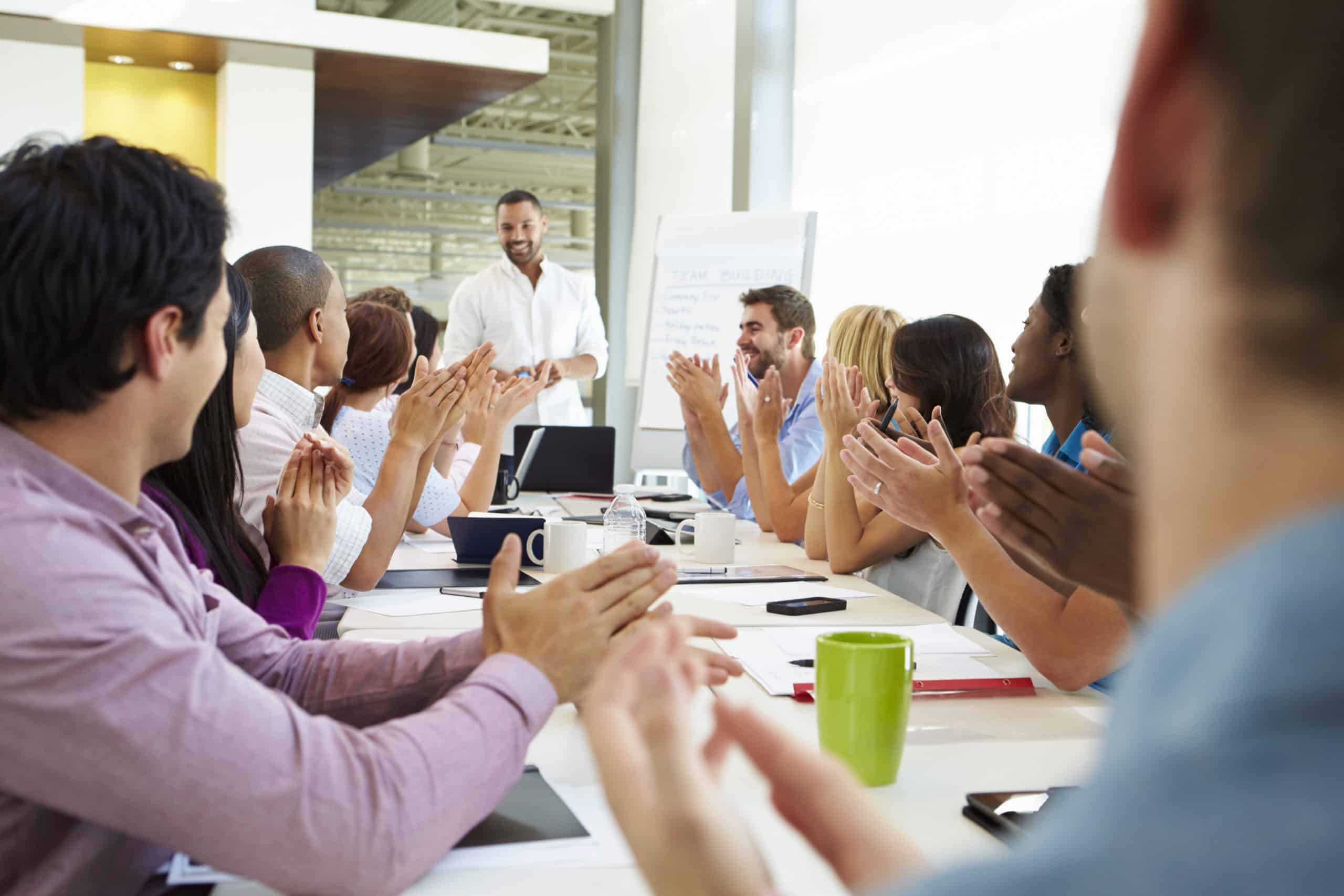 Businessman Addressing Meeting Around Boardroom Table